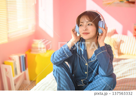 ベッドでヘッドホンをして音楽を聴く女性 ：はっぴぃぽっぷ 137563332