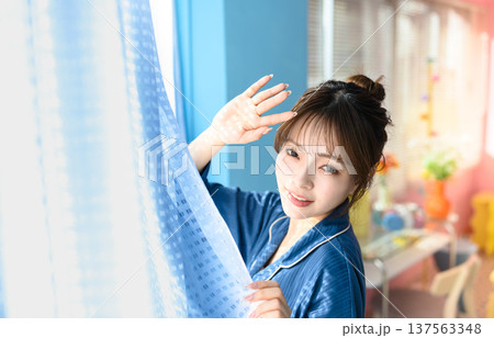 カーテン越しに微笑む若い女性 ：はっぴぃぽっぷ 137563348