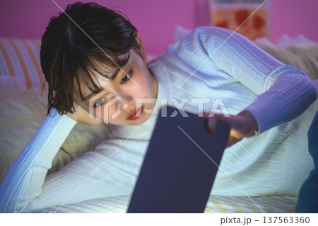 ベッドでタブレットを見る女性 ：はっぴぃぽっぷ 137563360
