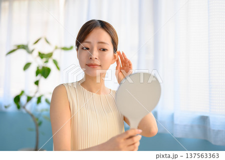 鏡で身だしなみをチェックする女性 ：はっぴぃぽっぷ 137563363
