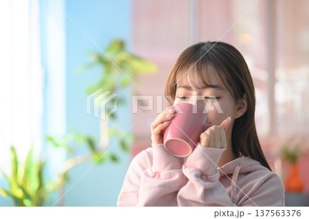 マグカップで飲み物を飲む女性 ：はっぴぃぽっぷ 137563376