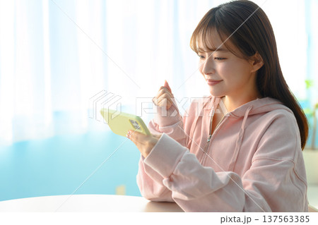 スマートフォンを見て喜ぶ若い女性 ：はっぴぃぽっぷ 137563385