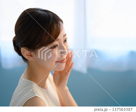 頬に手を当てて肌を確かめる女性 ：はっぴぃぽっぷ 137563387