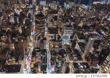 Aerial night view of Manhattan streets and illuminated skyscrapers with busy traffic in New York City USA Aerial night view of Manhattan streets and illuminated skyscrapers with busy traffic in New York City USA 137563466