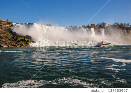 Niagara Falls waterfall with tourist boat approaching powerful cascade and mist Niagara Falls waterfall with tourist boat approaching powerful cascade and mist 137563497