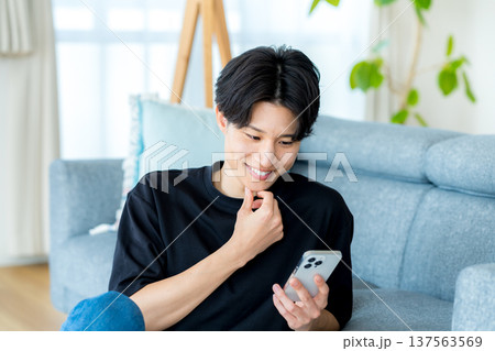 スマホを操作する若い男性 137563569