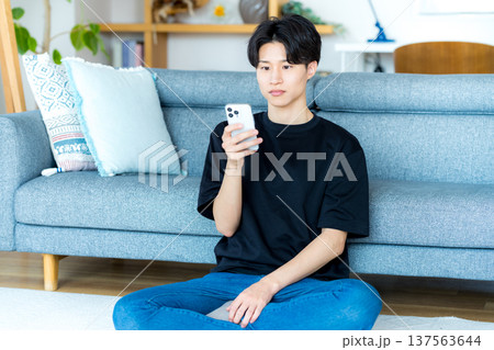 スマホを操作する若い男性 137563644