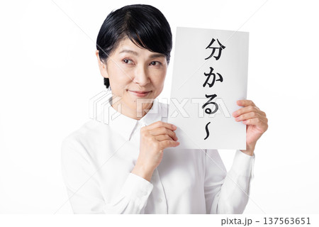 分かるーと書かれた紙を両手で持ちニヤリと笑う白いシャツを着たシニア女性 分かるーと書かれた紙を両手で持ちニヤリと笑う白いシャツを着たシニア女性 137563651
