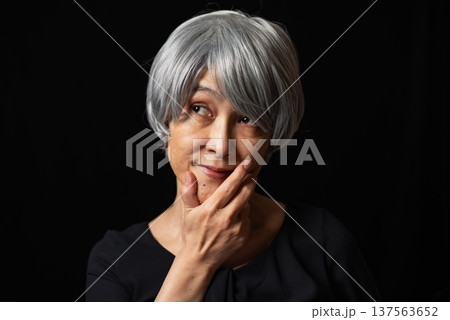 顎に手をあてニヤリと笑う白髪のシニア女性 137563652