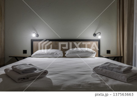 Symmetric Hotel Bedroom Detail with Double Bed and Reading Lamps 137563663