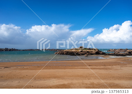 Rocky tidal island under bright skies in Tregastel, Brittany, France 137565313