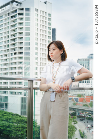 solo asian woman during outdoor break and relax at rooftop with city background solo asian woman during outdoor break and relax at rooftop with city background 137565894