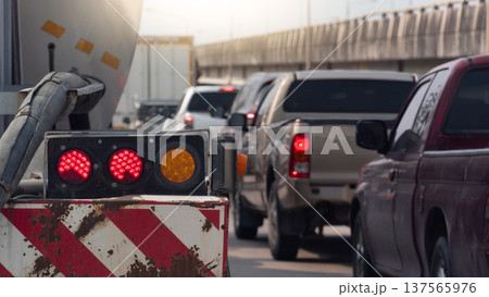 Rear side of truck chemical car with turn on brake light. Traffic jam on the road with many cars at daytime. Side of road with concrete bright. under bright sky. 137565976