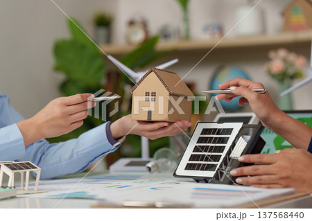 Sustainability in Action: Discussing Eco-Friendly Solutions with Model House and Solar Panel 137568440