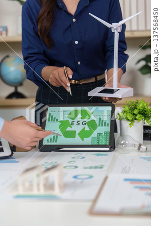Sustainability and ESG. Team collaborating on renewable energy solutions with visual data. 137568450