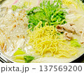 湯気立つ白いスープの鍋料理 野菜と麺を煮込む冬のあたたかい食卓 137569200