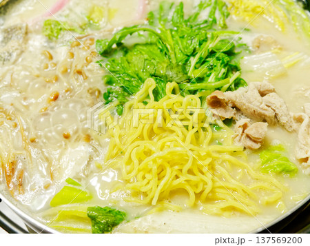 湯気立つ白いスープの鍋料理 野菜と麺を煮込む冬のあたたかい食卓 137569200