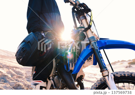 Motorcycle, helmet and man at desert for adventure, travel and lens flare. Motorbike, hand and closeup of rider in nature for freedom, sports training and driving on sand, dirt and off road journey 137569738