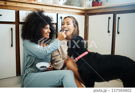 Lesbian, couple and happy with dog in kitchen, home or women eating breakfast together on the floor of apartment. Pet, animal and people with cereal or food in house with love, care and support Lesbian, couple and happy with dog in kitchen, home or women eating breakfast together on the floor of apartment. Pet, animal and people with cereal or food in house with love, care and support 137569802