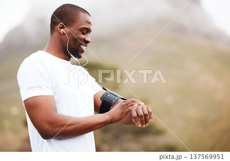Fitness, watch and music with a black man hiking in the forest for health, wellness or cardio on space. Exercise, time and smile with a happy young athlete in the mountains or nature for running 137569951
