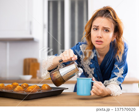 Sleepy woman drinking fresh coffee in morning 137570020