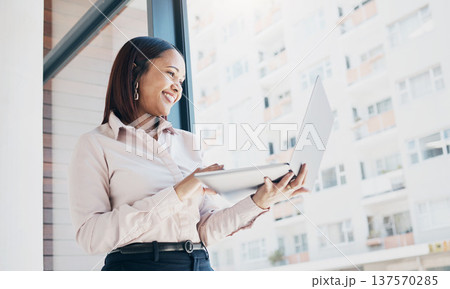 Happy woman at office window, holding laptop and reading email, schedule or online for feedback. Internet, networking or communication on website, businesswoman at human resources agency at low angle 137570285