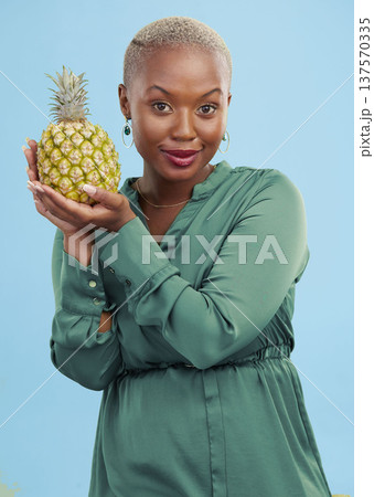 Portrait, pineapple for health or nutrition and a black woman in studio on a blue background for diet. Wellness, fruit or food with a confident young person looking confident for a healthy detox 137570335