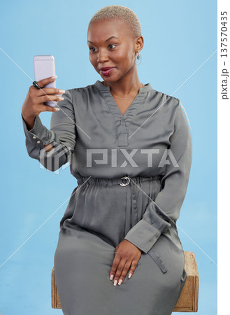 Smile, selfie and black woman beauty on app or video call isolated in studio blue background with style. Connection, African and influencer person or content creator live streaming on social media 137570435