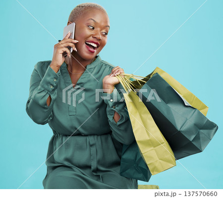 Shopping bag, studio phone call and happy black woman consulting on discount promotion, market sales or deal. Cellphone communication, mall gift advice and African customer talking on blue background Shopping bag, studio phone call and happy black woman consulting on discount promotion, market sales or deal. Cellphone communication, mall gift advice and African customer talking on blue background 137570660