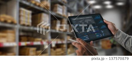 Logistics manager analyzing supply chain data dashboard on tablet inside warehouse storage facility. Concept of logistics analytics, inventory monitoring, digital warehouse management and technology Logistics manager analyzing supply chain data dashboard on tablet inside warehouse storage facility. Concept of logistics analytics, inventory monitoring, digital warehouse management and technology 137570879