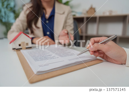 Real Estate Agreement. Client signing documents during home purchase consultation. Real Estate Agreement. Client signing documents during home purchase consultation. 137571145