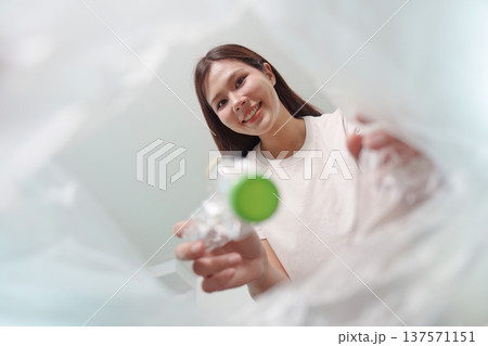 Recycling Initiative. Woman smiling while disposing of plastic waste. Recycling Initiative. Woman smiling while disposing of plastic waste. 137571151