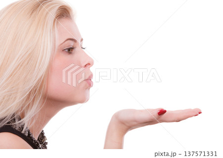 Blonde woman sending air kiss on palm hand Blonde woman sending air kiss on palm hand 137571331