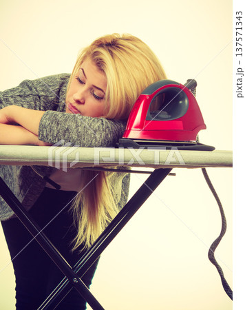 Sleepy tired woman having clothes to iron Sleepy tired woman having clothes to iron 137571343