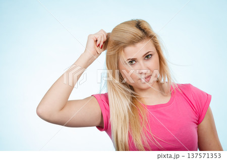 Woman brushing her long blonde hair with comb Woman brushing her long blonde hair with comb 137571353