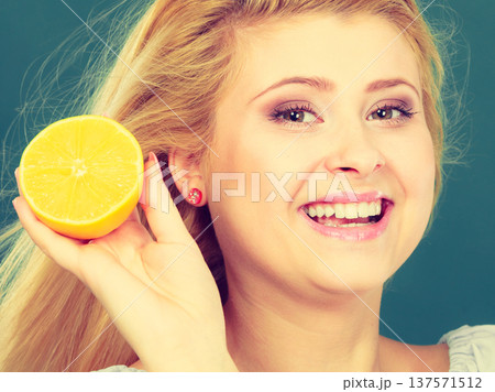 Woman holding fruit lemon half 137571512