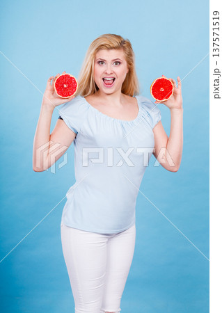 Woman holds grapefruit citrus fruit in hands Woman holds grapefruit citrus fruit in hands 137571519