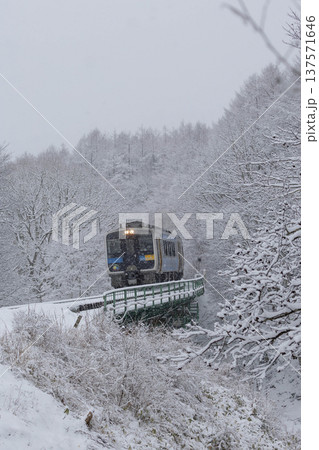 降雪の中県境の鉄橋を渡る小海線キハ200形 137571646