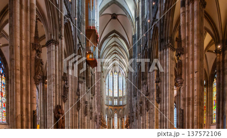 Interior view of Cologne Cathedral in Germany. Tall stone columns, intricate arches, and colorful stained glass windows create a majestic atmosphere. Interior view of Cologne Cathedral in Germany. Tall stone columns, intricate arches, and colorful stained glass windows create a majestic atmosphere. 137572106
