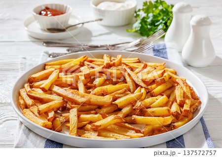 Plate of crispy golden french fries, top view 137572757