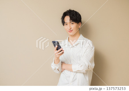 スマホを見る若い男性　 137573253