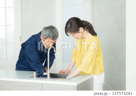 水回りの説明をする作業服の男性 137573261