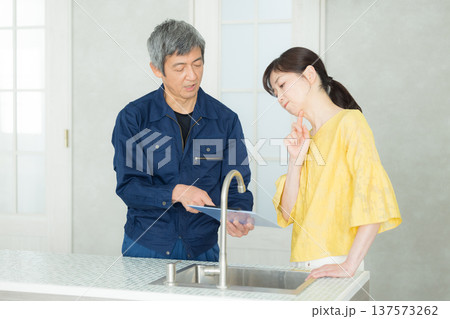 水回りの説明をする作業服の男性 137573262