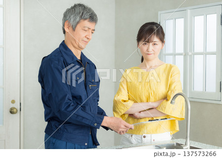 水回りの説明をする作業服の男性 137573266