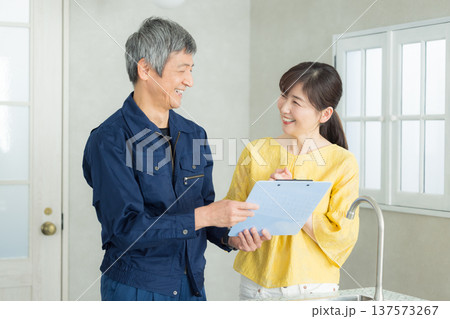 水回りの説明をする作業服の男性 137573267