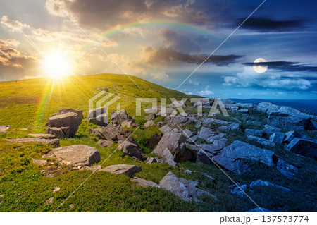 rocks and rolling hills in mountain landscape on summer solstice. day meet night. sun and moon over scenery with green grass on alpine meadow. astrology recreation tourism and wanderlust rocks and rolling hills in mountain landscape on summer solstice. day meet night. sun and moon over scenery with green grass on alpine meadow. astrology recreation tourism and wanderlust 137573774
