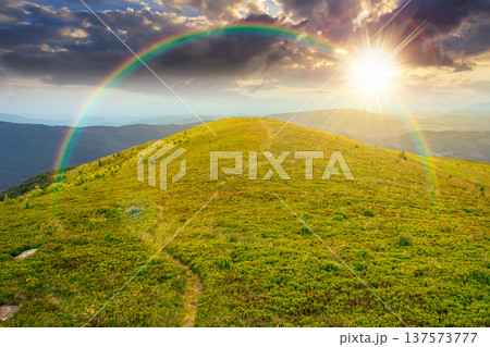 sunset over summer landscape of alps. hillside meadows in mountain scenery. countryside highland view from the top of a hill. nature background with green slope. weather with rainbow sunset over summer landscape of alps. hillside meadows in mountain scenery. countryside highland view from the top of a hill. nature background with green slope. weather with rainbow 137573777