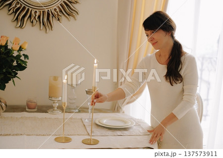 Woman lighting candles preparing dining table at home 137573911