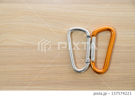 木目背景に並んだ2色のアルミカラビナ 137574221