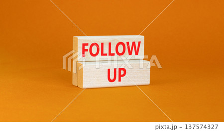 Follow up symbol. Concept word Follow up on beautiful wooden blocks. Beautiful orange paper background. Business follow up concept. Copy space. 137574327